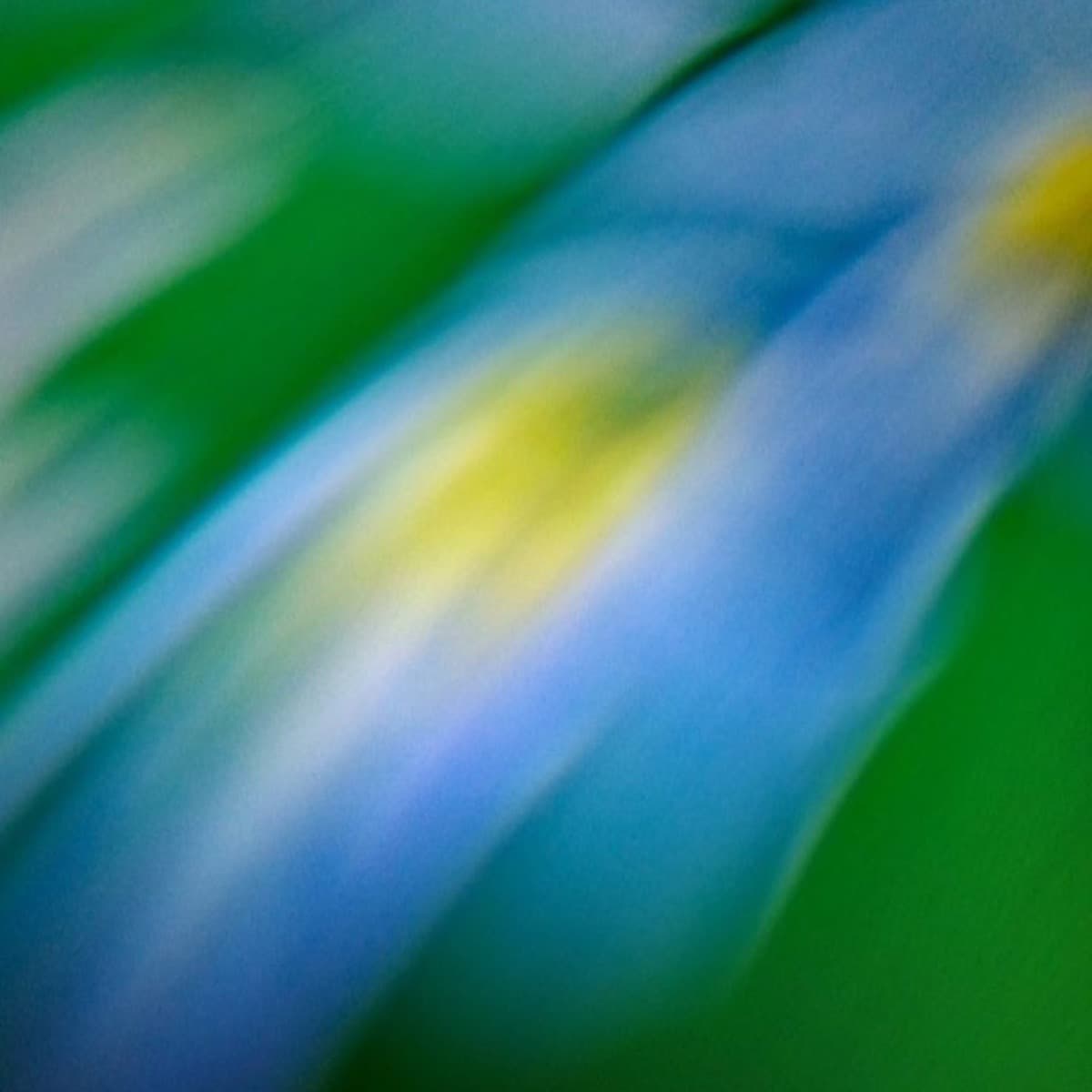 An abstract blur of cool blue and green tones in motion.